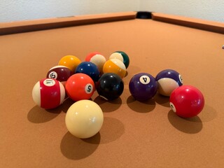 Billiards Table 9-Ball Game: Pool table with beige felt cloth featuring multiple balls arranged for a game.