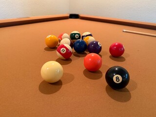 Billiards Table 9-Ball Game: Pool table with beige felt cloth featuring multiple balls arranged for a game.