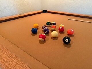 Billiards Table 9-Ball Game: Pool table with beige felt cloth featuring multiple balls arranged for a game.