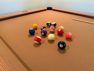 Billiards Table 9-Ball Game: Pool table with beige felt cloth featuring multiple balls arranged for a game.