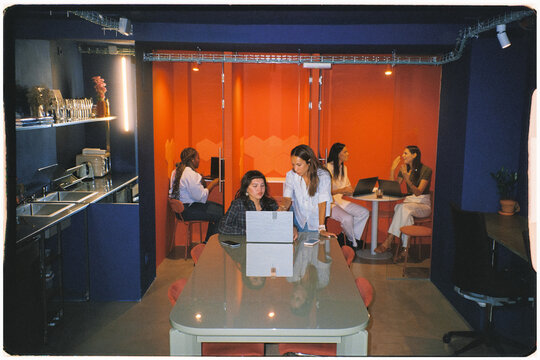 Analog wide-angle shot of multiple female teams collaborating