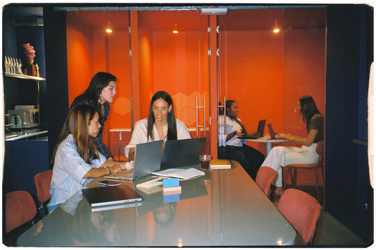 Wide-angle analog view of female teams working together in an office
