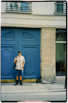 Analog portrait of a tourist photographer posing in front of a door