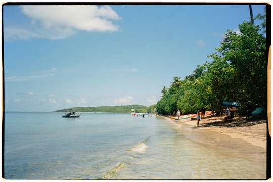 A quiet beach with unrecognizable tourists enjoying a sunny day