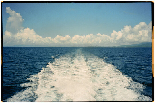 The wake of water and foam left by a ferry crossing the sea