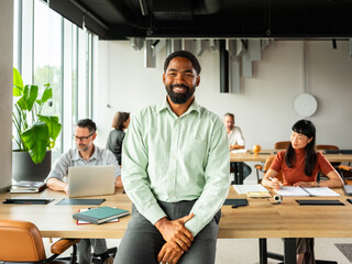 Confident Black Man In Office Setting With Colleagues 