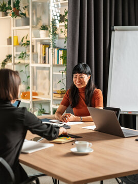 Friendly Business Meeting Between Two Women in Modern Office Set