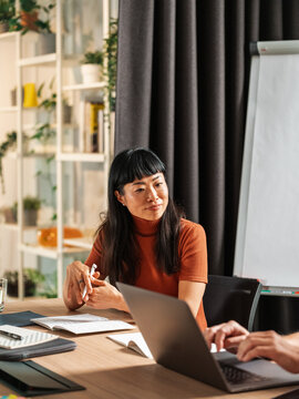 Professional Woman in Orange Turtleneck Leading a Meeting 