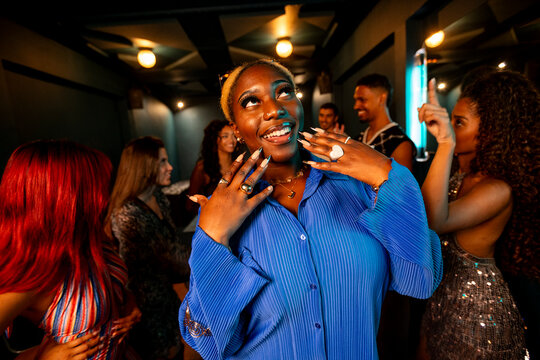 Girl with fancy nails dancing with friends in a night club 