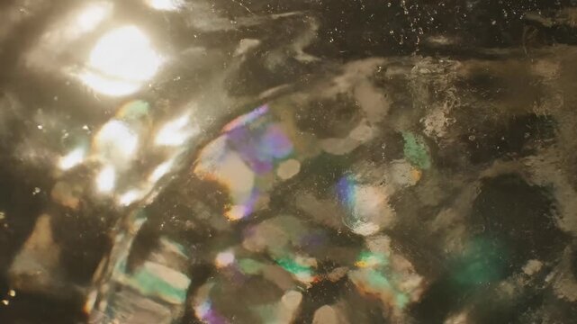 Extreme close-up cinematic shot of sunlight refracting and distorting through rippled, thick glass, creating abstract wavy color patterns effect, minimalism, reflection