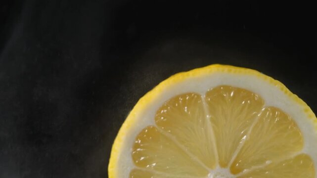 A macro shot of a juicy lemon slice against a solid black background.