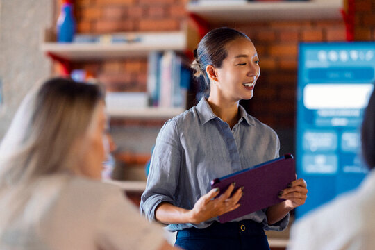 Professional Woman Leading Discussion With Tablet