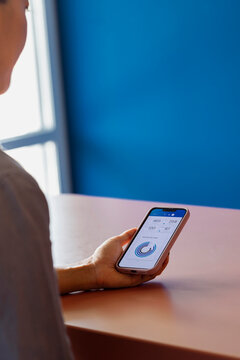 Person Holding Smartphone Displaying Data Chart On Screen