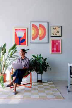 Focused Woman With Laptop In Modern Bright Office