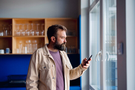 Man Using Smartphone in Modern Kitchen 