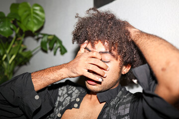 Young black man thinking with his hand on his face