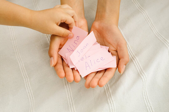 Children look at the pieces of paper with the names on them 