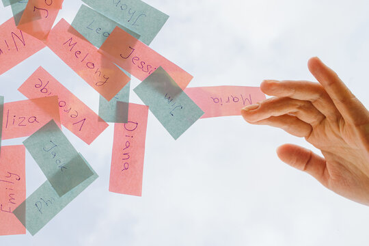 pink and blue pieces of paper with male and female names 