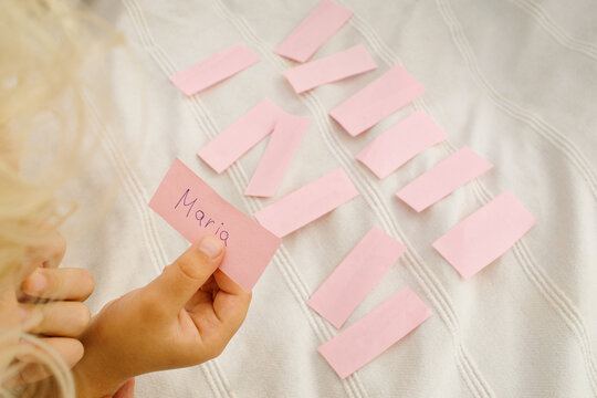 Children look at the pieces of paper with the names on them 