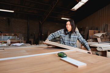 Woman Handling Wooden Boards in Workshop