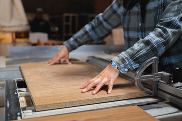 Hands Guiding Wood Through Table Saw