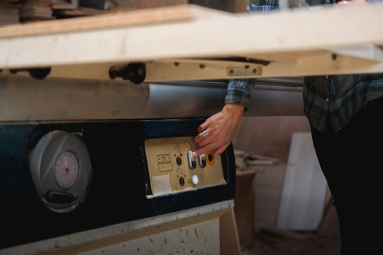 Turning On the Table Saw in a Wood Workshop