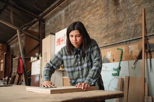Female Woodworker Refining Wooden Surface