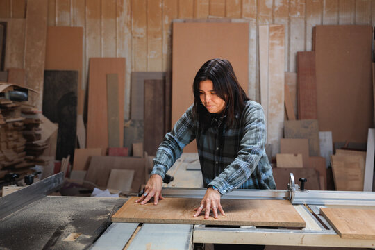 Female Carpenter Cutting Wood with Precision
