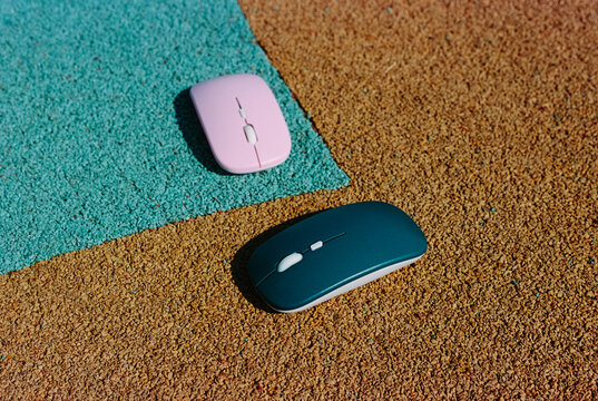 pink and teal wireless mice on bright ground, 35mm film