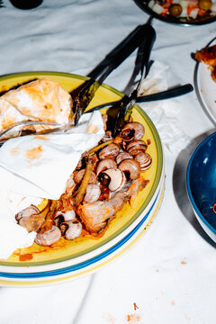 a messy plate with chicken bones and snail shells after a meal