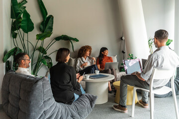 Casual Business Meeting In Modern Lounge With Diverse Team 