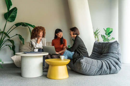Three Women Have a Casual Business Meeting in a Modern Lounge