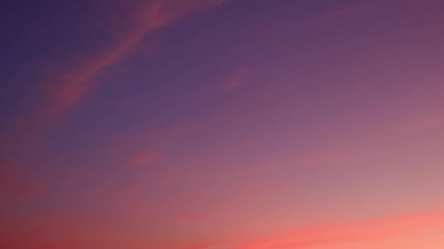 A sunset sky timelapse showcasing soft cirrus and altocumulus clouds brushed in pink and orange hues, creating a smooth gradient as delicate streaks drift across the fading daylight. Time-lapse.
