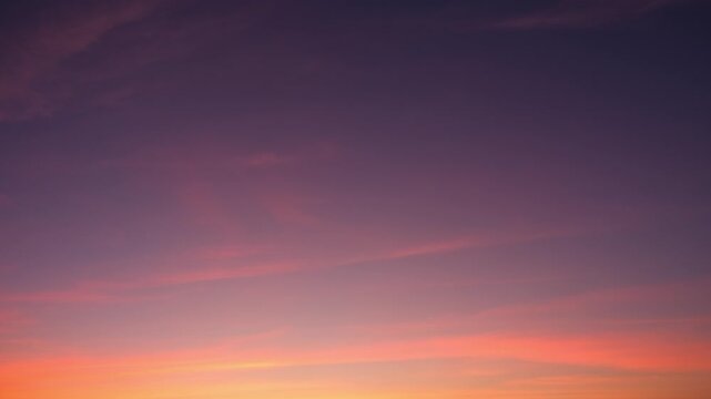 A serene sunset sky timelapse featuring soft cirrus and altostratus clouds glowing in gentle pink and orange layers as evening light fades, capturing smooth cloud movement across dusk. Time-lapse.
