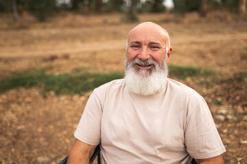 Portrait of bald man with white beard smiling at camera