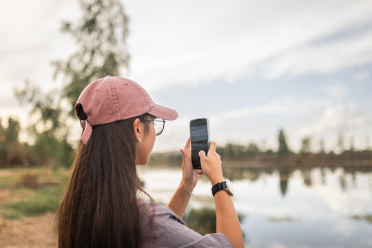 Young woman taking a photo with mobile while camping