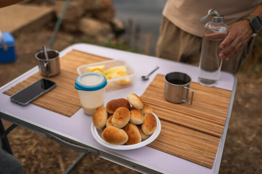 Coffee and pastries on table with partial view of man