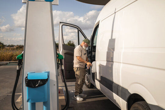 Mature man refueling his van at a gas station