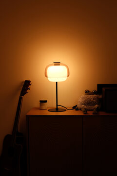 Dark cozy interior details. Lamp with a warm light switched on 