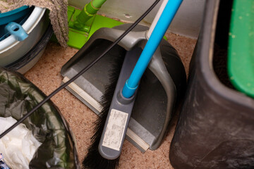 Old cleaning tools placed on floor, Worn janitor supplies arranged on gritty concrete surface