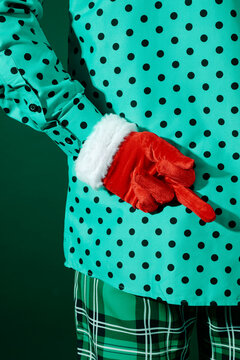 a man in green outfit seen from behind showing a middle finger gesture