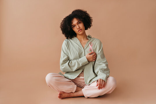 Sitting Gracefully in Pastel Tones With a Cancer Awareness Ribbon
