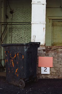 A rusty trash can near the factory exit.