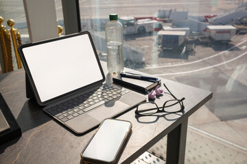 Travel Workspace at Airport With Tablet, Glasses, and Earbuds