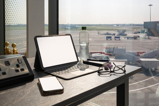 Working Before Traveling at the Airport With Tech Devices on a Table