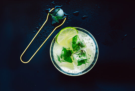 Refreshing cocktail with mint and lime on dark surface