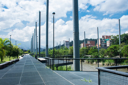 Scenic Park Pathway With Tall Poles and Clear Blue Sky in Medellin