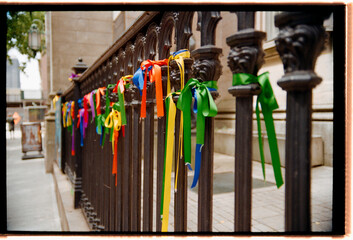 Colorful Ribbons Tied to a Fence in a City Street