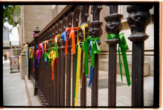 Colorful Ribbons Tied to a Fence in a City Street