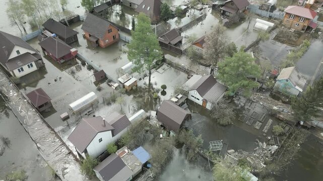 Aerial drone footage showing severe flooding with submerged houses and roads. Wide overhead view of a disaster zone after heavy rainfall, showcasing water damage, extreme weather, and climate-related 